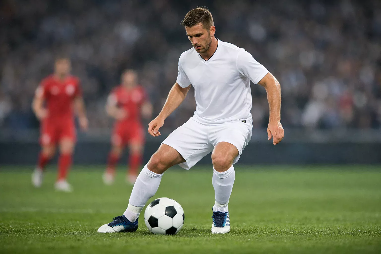Midfielder controlling the football with close ball control during a match