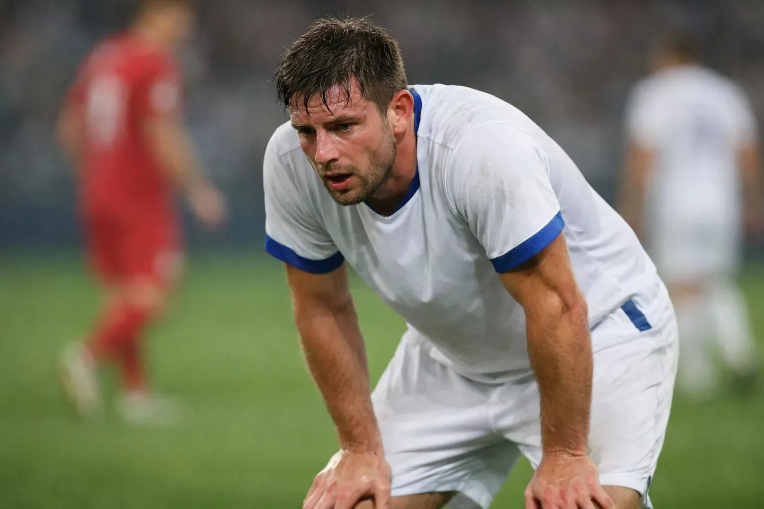 Fatigued footballer taking a moment during a break in play on the pitch